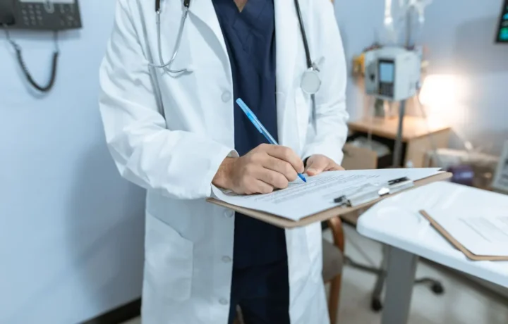 Medic completând documente medicale